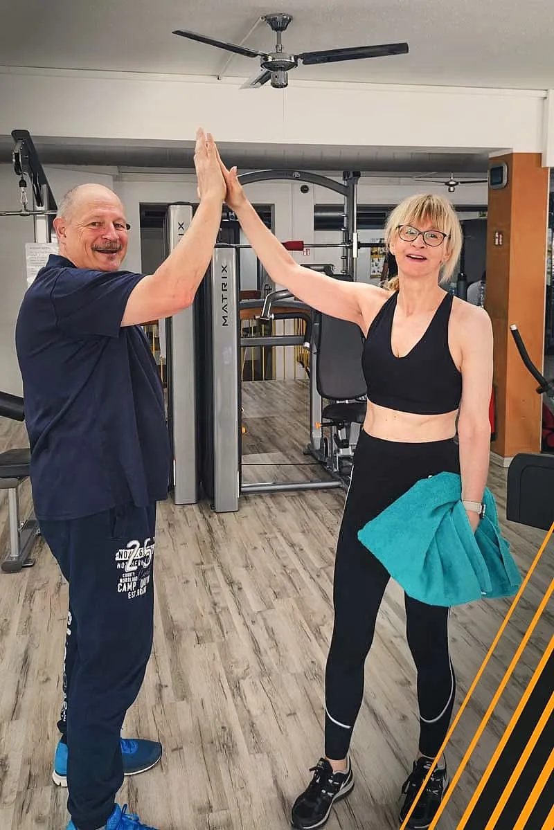 Zwei Mitglieder klatschen sich im Studio lächelnd ab